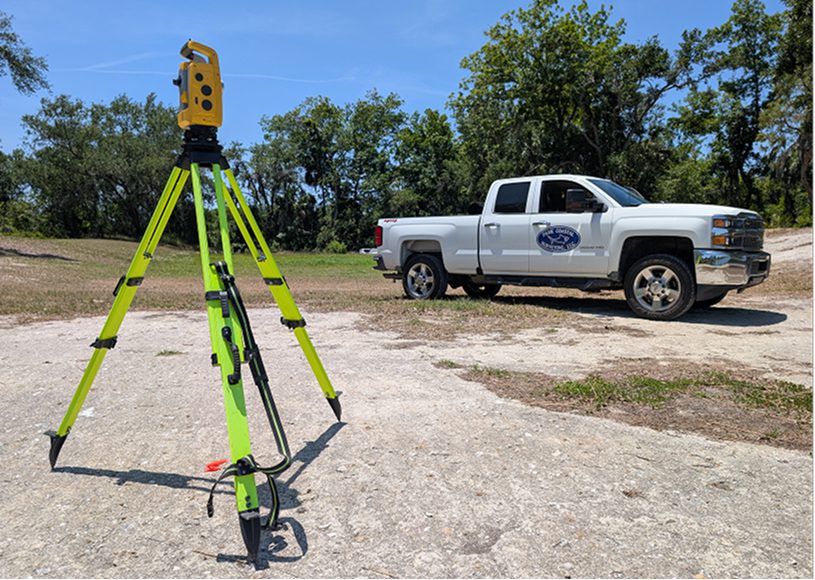 Surveying equipment and truck on a field.